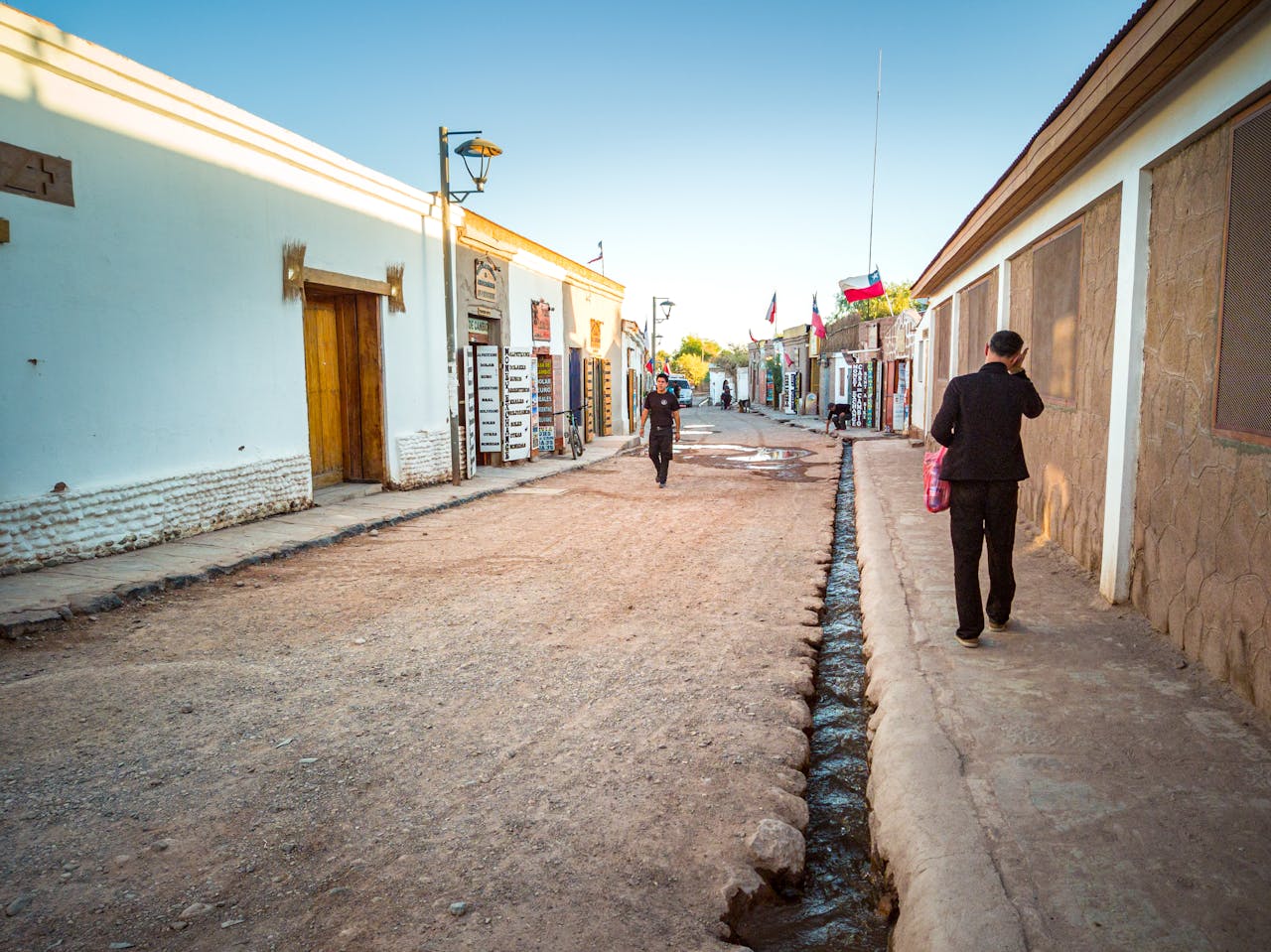 A quaint street in San Pedro de Atacama, Chile, showcasing traditional architecture and daily life.